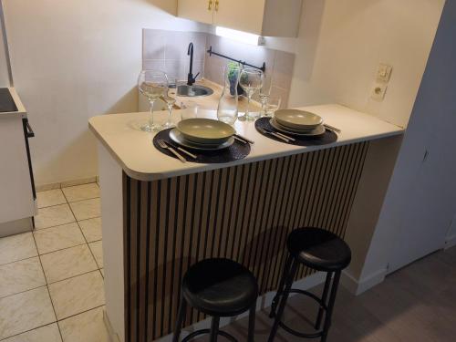 a kitchen with a counter with plates and wine glasses at Magnifique T2 Centre Ville in Le Havre