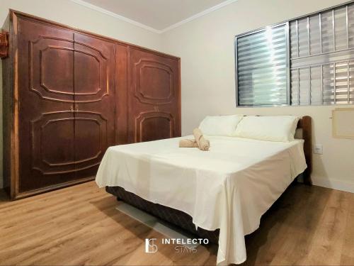 a bedroom with a bed with a teddy bear on it at Casa - Centro Px Matriz c/ Churrasqueira, 2 Suítes in Poços de Caldas