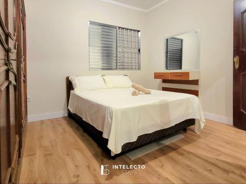 a bedroom with a bed with a teddy bear on it at Casa - Centro Px Matriz c/ Churrasqueira, 2 Suítes in Poços de Caldas