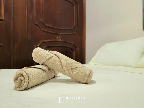 a towel sitting on top of a bed at Casa - Centro Px Matriz c/ Churrasqueira, 2 Suítes in Poços de Caldas