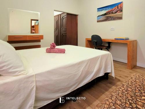 a bedroom with a bed with a pink stuffed animal on it at Casa - Centro Px Matriz c/ Churrasqueira, 2 Suítes in Poços de Caldas