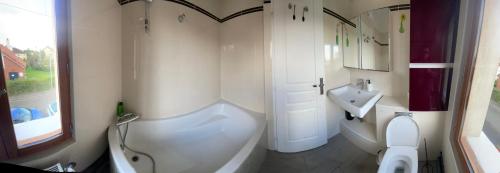 une salle de bain avec une baignoire, des toilettes et un lavabo dans l'établissement Chambre de Joy, à Argenteuil