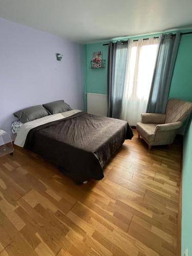 une chambre avec un lit et une chaise dans l'établissement Chambre de Joy, à Argenteuil