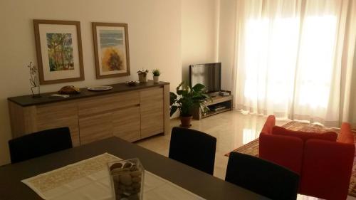 sala de estar con mesa de comedor y TV en Stay Like Home Milano, en Corsico