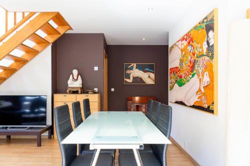 Un comedor con una mesa y sillas blancas. en Dúplex Artístico con Terraza I 10 min del Centro I AndBnB, en Santa Coloma