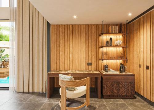 a home office with a wooden desk and a chair at Banyan Tree Mayakoba in Playa del Carmen