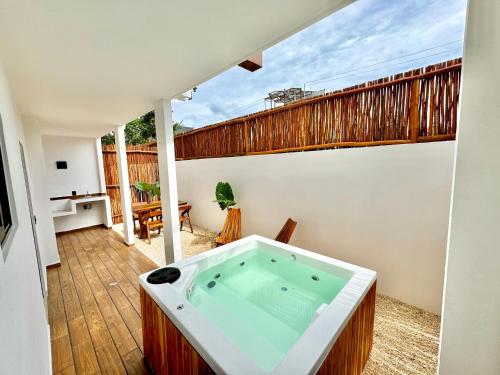 a jacuzzi tub in a room with a balcony at Chic 2BR Condo, Private Jacuzzi and 2 Free Bikes in Tulum