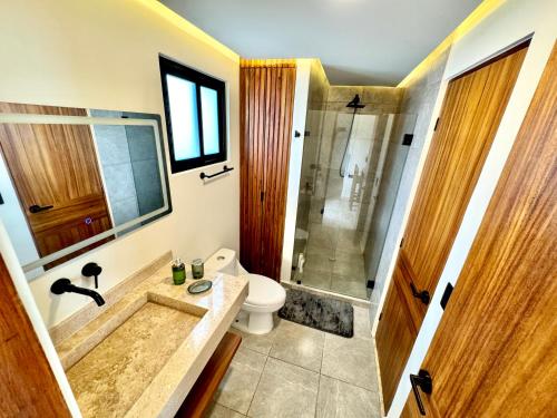 a bathroom with a tub and a toilet and a shower at Chic 2BR Condo, Private Jacuzzi and 2 Free Bikes in Tulum