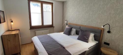 sypialnia z łóżkiem z 2 lampami i oknem w obiekcie Ferienwohnung Hafner w Mayrhofen