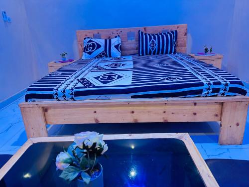 a bed in a room with a blue light at Yoda home in Saint-Louis