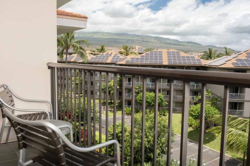 a balcony with two chairs and solar panels at Maui Coast Hotel in Kihei