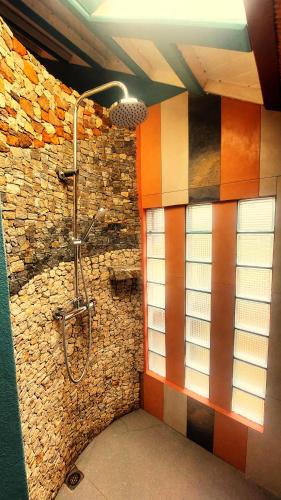 a bathroom with a shower in a brick wall at Samaria Lodge in Sainte Marie