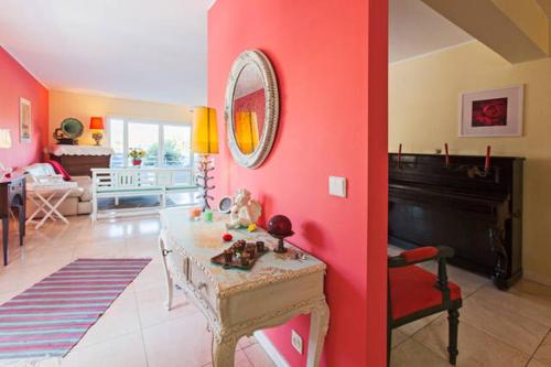 a living room with a red wall and a table at CAMINHOS DE SANTIAGO - VillaMaria BEACH HOUSE in Leça da Palmeira