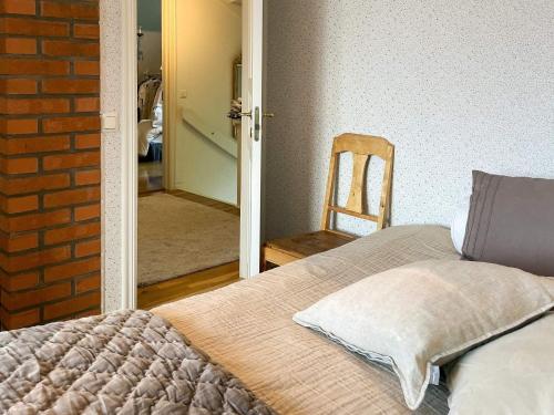 a bedroom with a bed and a chair and a mirror at 5 star holiday home in Uddevalla in Sundsandvik