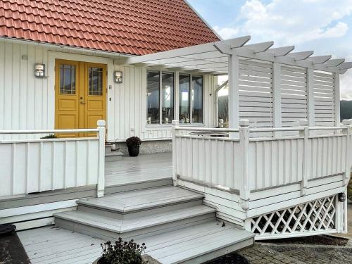 a white house with a porch and a yellow door at 5 star holiday home in Uddevalla in Sundsandvik