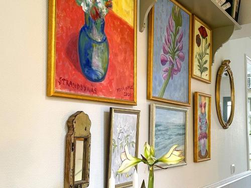 a wall with paintings and a blue vase on it at 5 star holiday home in Uddevalla in Sundsandvik