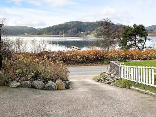 a road next to a lake with a white fence at 5 star holiday home in Uddevalla in Sundsandvik