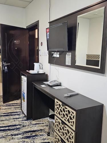 a room with a desk with a computer and a mirror at فندق سواعد العالمية مكة المكرمة الحرم - Sawaed International Hotel Makkah Al-Haram in Mecca