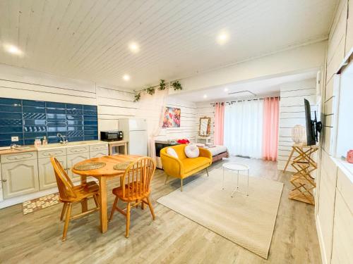 un salon avec une table et une chaise jaune dans l'établissement Le Chalet des Cœurs Enlacés - Wifi Parking, au Chambon-sur-Lignon