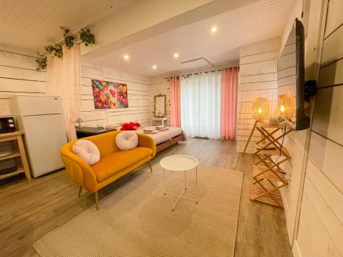 un salon avec un canapé et une table dans l'établissement Le Chalet des Cœurs Enlacés - Wifi Parking, au Chambon-sur-Lignon