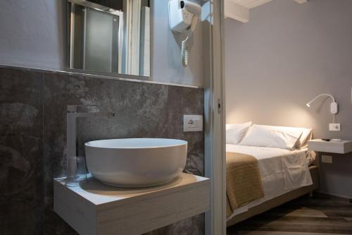 a bathroom with a bowl sink and a bed at AL 54 Accommodation in San Benedetto del Tronto