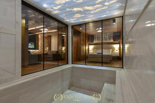 a bedroom with a bed in a room with windows at HOTEL EMROVIC RAJ in Novi Pazar