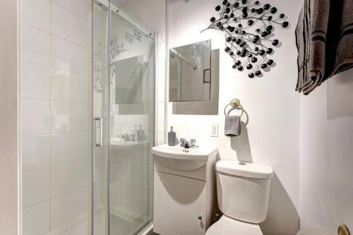 a bathroom with a shower and a toilet and a sink at Le Magnifique - Close by Downtown in Montréal