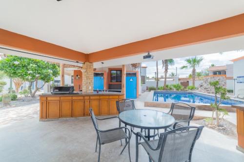 a patio with a table and chairs and a pool at GoBaja Villas 3 bedroom in La Paz