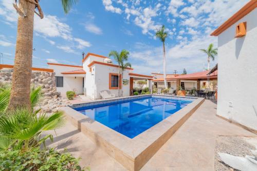 a swimming pool in the backyard of a house with palm trees at GoBaja Villas 3 bedroom in La Paz
