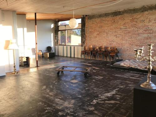 a room with a table and chairs and a brick wall at Eventyrligt og rummeligt hus med havudsigt in Borre
