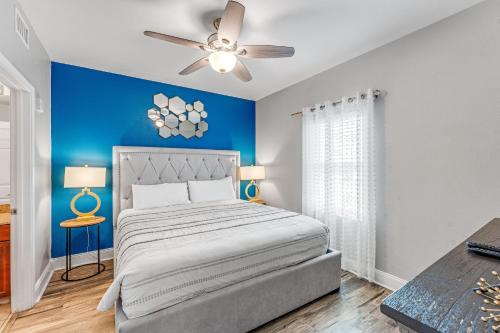 巴拿马城海滩Laketown Wharf #1219 by Nautical Properties的一间卧室设有蓝色的墙壁和一张带吊扇的床。