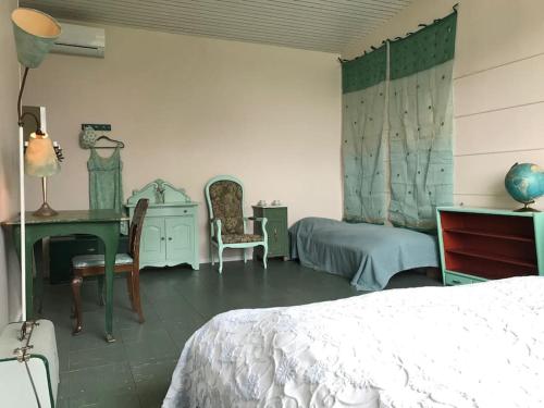 a bedroom with a bed and a desk and a table at Eventyrligt og rummeligt hus med havudsigt in Borre