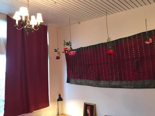 a room with a red curtain and a window at Eventyrligt og rummeligt hus med havudsigt in Borre