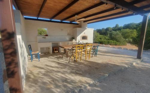 a patio with a wooden table and chairs at Tenuta Marinelli in Cisternino