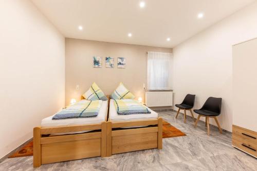 a bedroom with a bed and two chairs at Rheinland Apartments - Stilvolle, moderne Unterkunft mit kostenfreiem WLAN und Parkplatz in Andernach