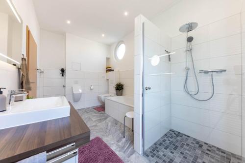 a white bathroom with a shower and a sink at Rheinland Apartments - Stilvolle, moderne Unterkunft mit kostenfreiem WLAN und Parkplatz in Andernach