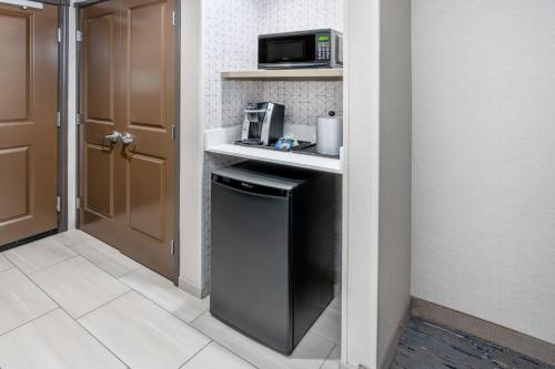 a small kitchen with a refrigerator and a microwave at Holiday Inn Express Hotel & Suites Cheyenne by IHG in Cheyenne