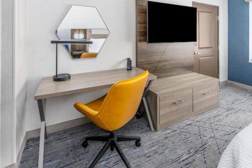 a desk with a chair and a television in a room at Holiday Inn Express Hotel & Suites Cheyenne by IHG in Cheyenne