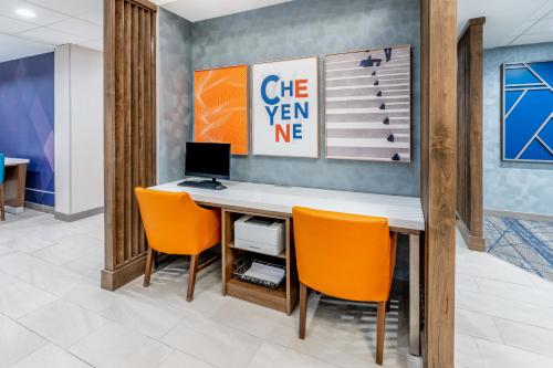 an office with a desk with a computer and orange chairs at Holiday Inn Express Hotel & Suites Cheyenne by IHG in Cheyenne