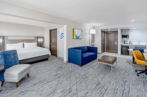 a hotel room with a bed and a blue chair at Holiday Inn Express Hotel & Suites Cheyenne by IHG in Cheyenne