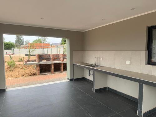 a large kitchen with a sink and a counter top at Unit B1 Motswedi Place in Gaborone