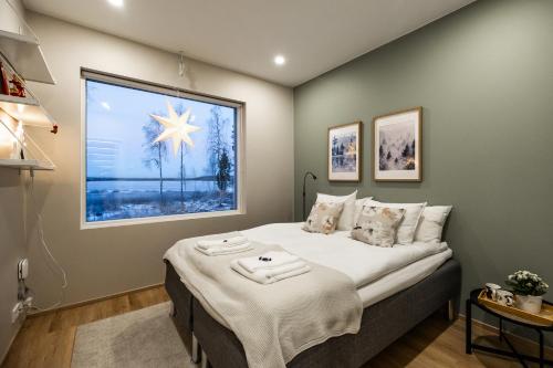 Un dormitorio con una cama con una ventana grande. en Villa Forest -private location, sauna and jacuzzi, en Rovaniemi