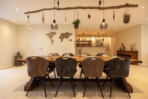 a dining room with a large wooden table and chairs at B&B Iets Zeeuws in Kats