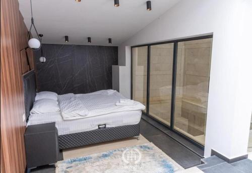 a bedroom with a bed and a large window at HOTEL EMROVIC RAJ in Novi Pazar