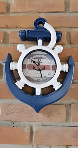 a clock is attached to a brick wall at Suítes Praiamar VISTA LINDA Bertioga in Bertioga