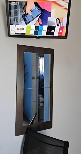 a mirror on a wall next to a tv at Suítes Praiamar VISTA LINDA Bertioga in Bertioga