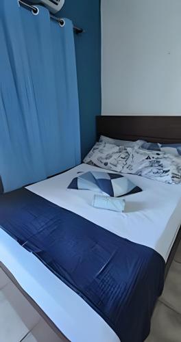 a blue and white bed in a room at Suítes Praiamar VISTA LINDA Bertioga in Bertioga