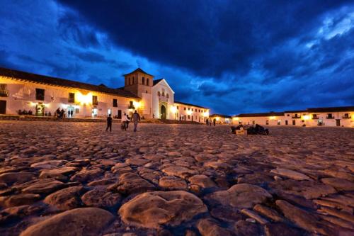a cobblestone street in front of a building at night at Apartamento PUERTA DE LA VILLA in Villa de Leyva
