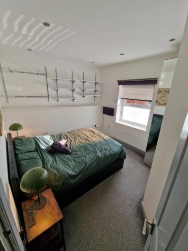 a bedroom with a green bed and a window at Smart Town Centre Apartments in Northampton