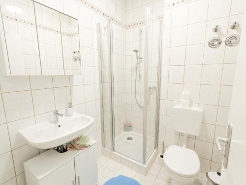 a bathroom with a shower and a toilet and a sink at UO0 - Urlaubsmagie - Gemütliche Wohnung für bis zu 6P in Sebnitz